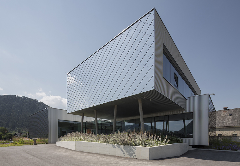 Die Schmalseiten des Bürogebäudes der S. Jaritz Stahlbau & Montage GmbH werden je zweimal im Erd- und Obergeschoss mit einer Fassade aus Edelstahlrauten markiert.